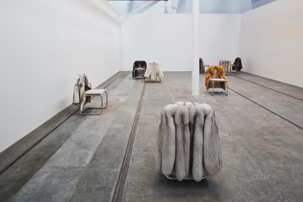 image of chairs with fur coats hanging off of them