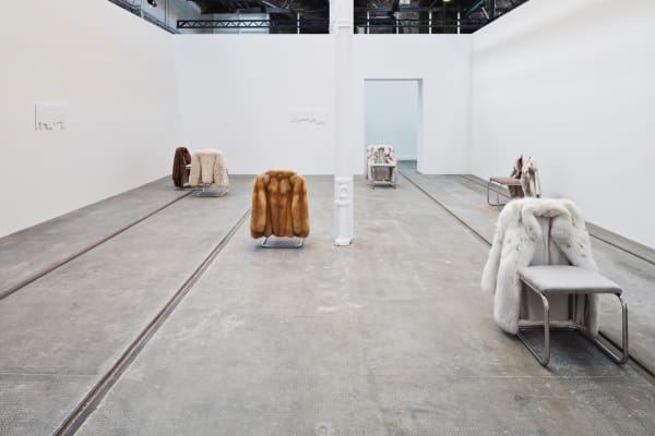 image of chairs with fur coats hanging off of them