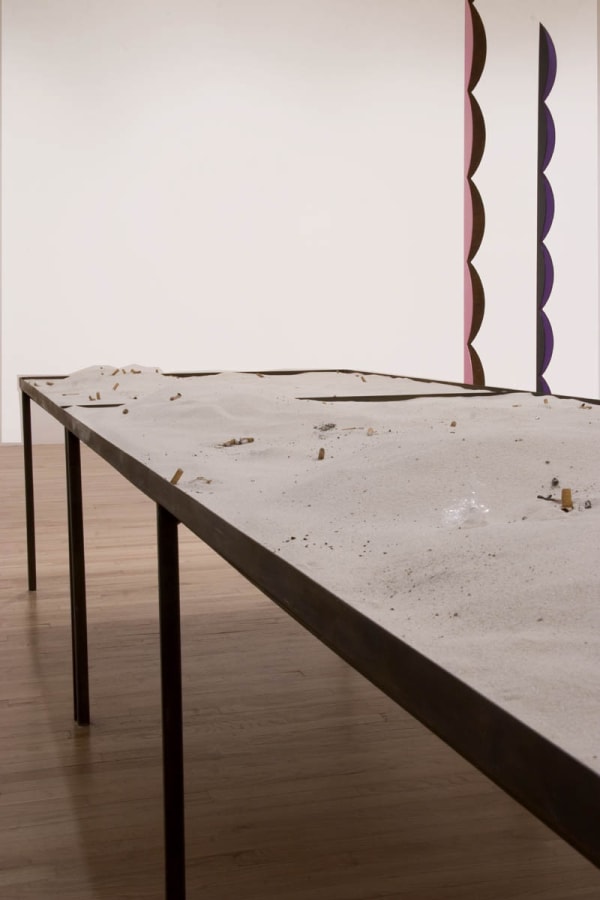 image of Nicole Wermers circular sculpture with table of sand and cigarettes