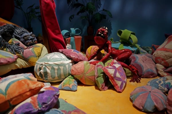 Djurberg and Berg colorful soft puppet sculptures installed in a whimsical corner of the museum gallery full of pillows and cushions