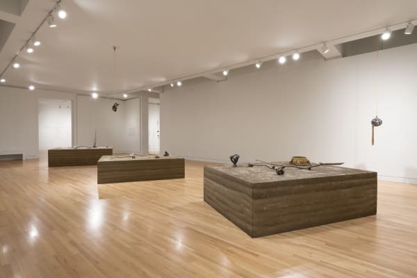 a group of earth colored sculptures within a gallery with white walls and wood floors