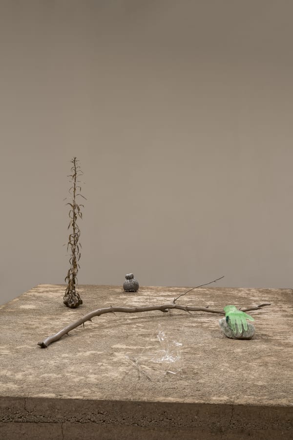 an earth colored sculpture within a gallery with white walls and wood floors