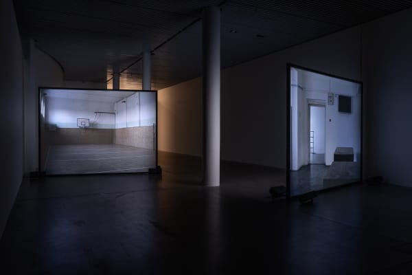 Susan Philipsz's film still image, two channel projection of concrete building facades in dark room