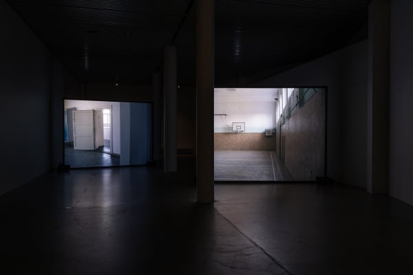 Susan Philipsz's film still image, two channel projection of concrete building facades in dark room