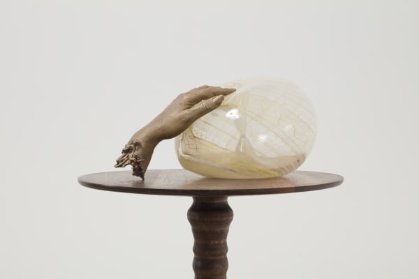 Akashi bronze hand dipping into glass sculpture