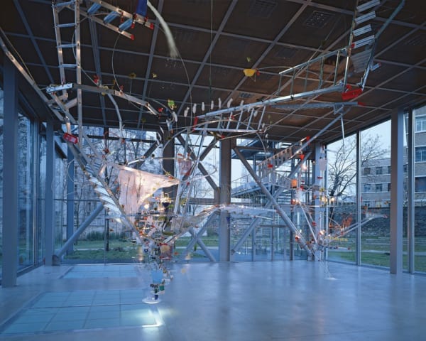 Image of Sarah Sze installation of ladders and other objects circling from ceiling to floor