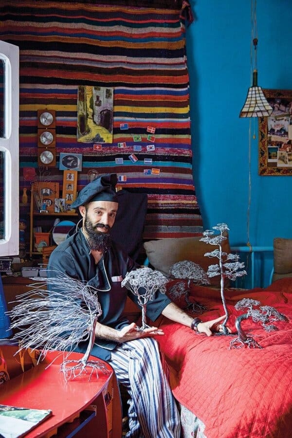 Lezaar, dressed for work, with his intricate wire sculptures.