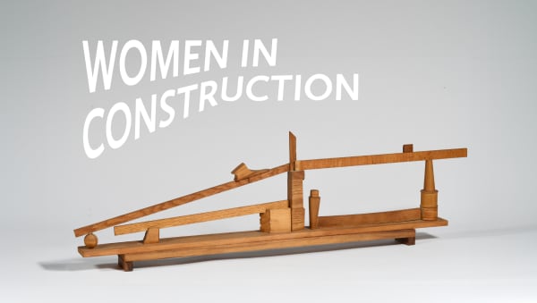 an image with a wooden sculpture and the words "Women in Construction" above