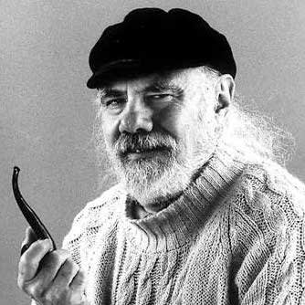 Black and white photograph of a man with a white beard and white hair holding a smoking pipe and looking at the camera.