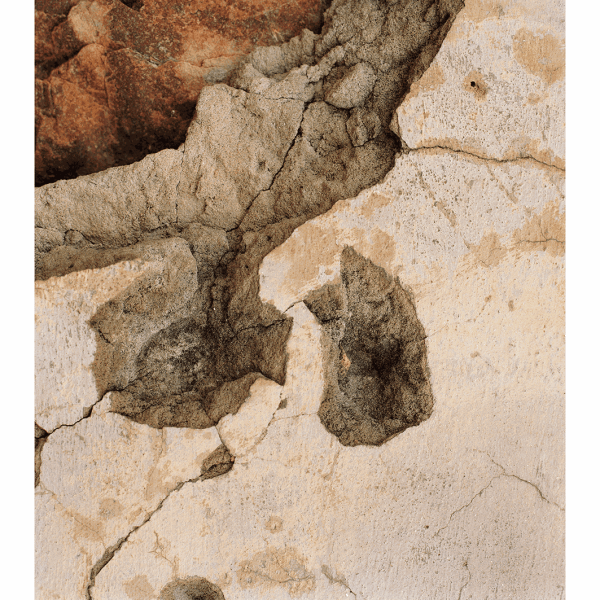 A crumbling wall with bullet-hole debris