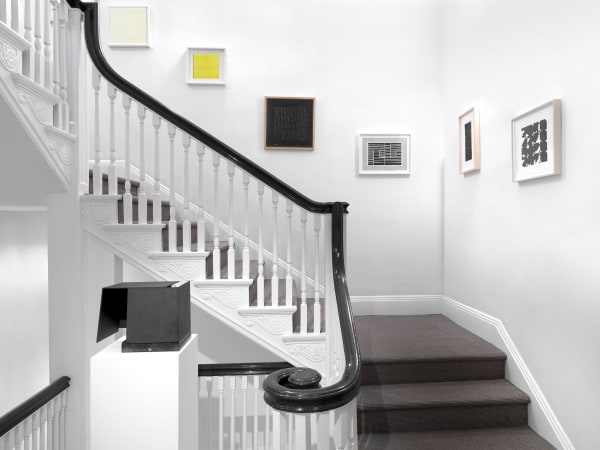Jorge Oteiza's sculpture Caja Metafisica (1972-1974) on the front. Works on paper by Sol LeWitt, Willys de Castro, Anni Albers, Helio Oiticica, Lygia Clark, and Elena Asins on the staircase's walls.