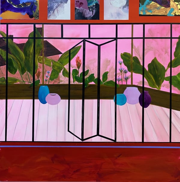 A view of a balcony from inside an interior with a deep red floor in the foreground, the glass doors outlined in black with a view of the outside area in shades of bubble gum pink with exotic plants in the background.
