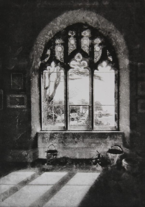 Lindsey Moran tonal print of a large gothic window with light falling on the floor in the foreground. A large tree and small houses are visible through the window.