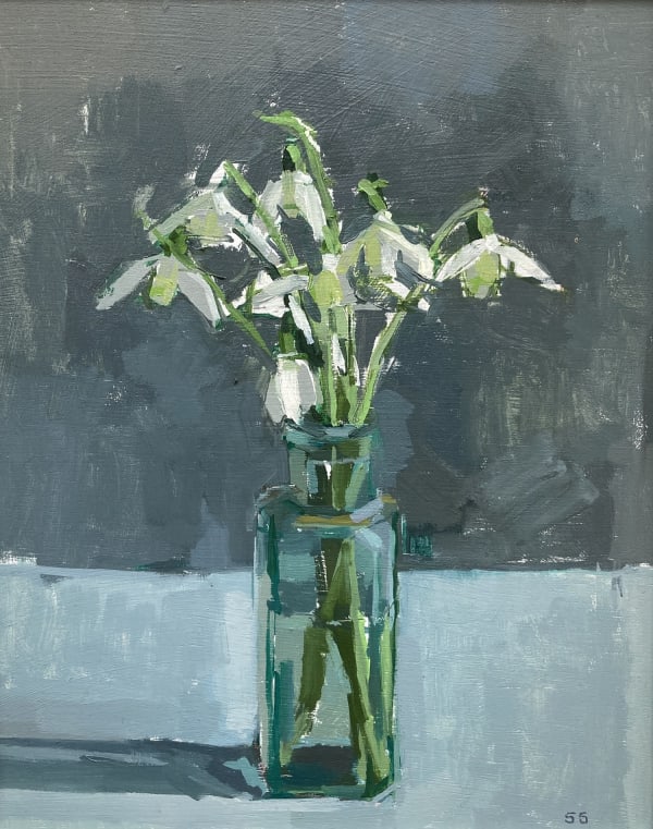 Sarah Spackman figurative still life painting of a bunch of Snowdrops resting in bottle necked vase full of water. The surface is painted in hues of pale blues and the background in steel greys.