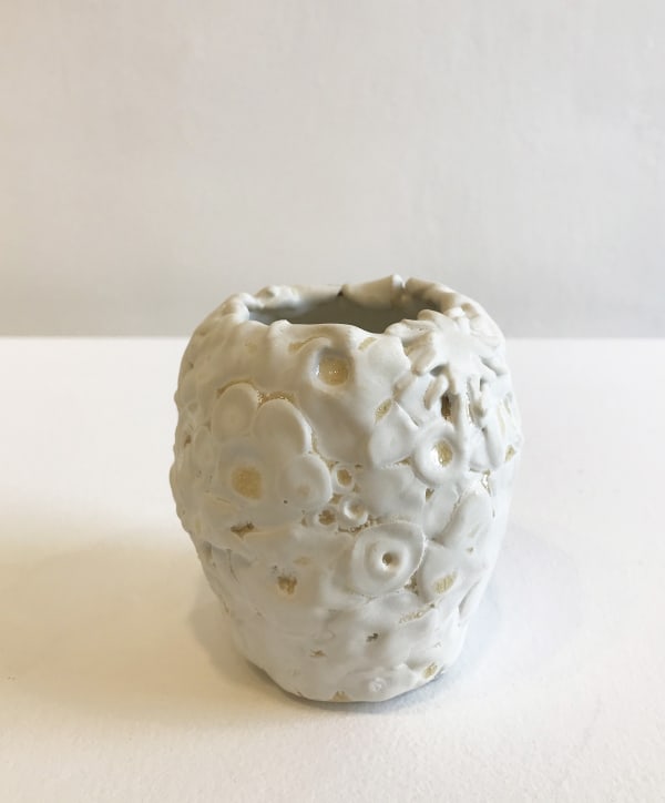 Emma Jagare hand built porcelain mini white vase showing dimensional detail of a variety of pressed flower heads.