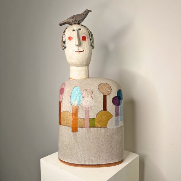 Jane Muir ceramic sculpture of a figure with bird on his head and a rainbow forest around his midriff