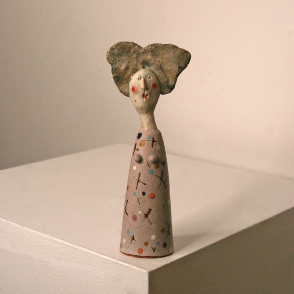 Jane Muir Minimalist ceramic sculpture of a little lady, with a spotted purple, pink and orange dress