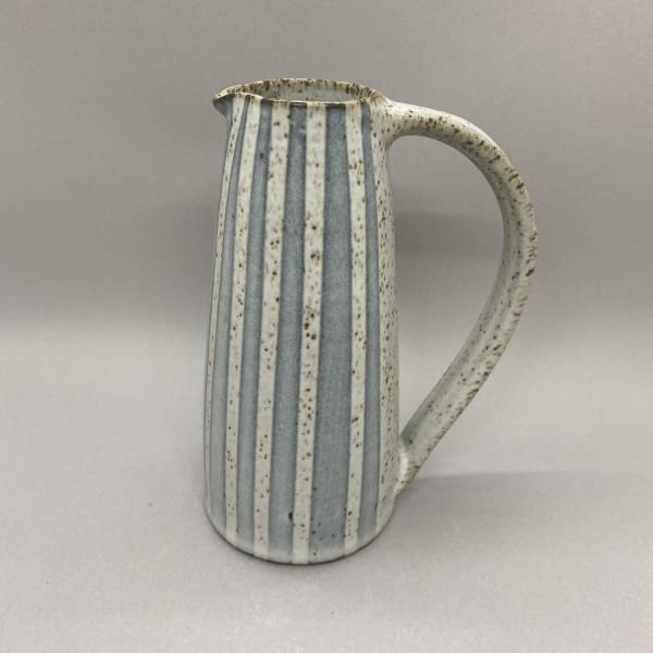 Kate Garwood narrow jug in a straight shape with a white glaze and blue stripes.