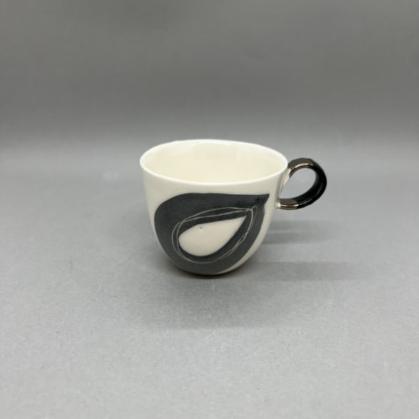 Fliff Carr ceramic espresso cup with painted black droplet pattern and with a black and gold handle.