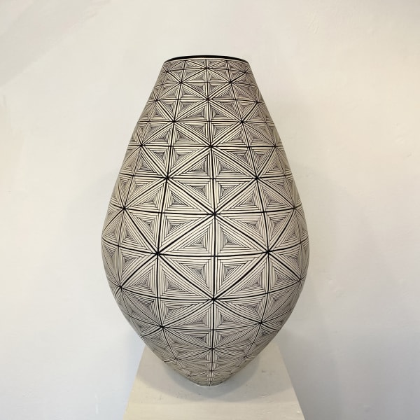 Ant & Di Edmonds - Tydd Pottery wide, heart shaped ceramic black and white vessel with a vertical zig zag pattern. tall, elongated ceramic vessel decorated with a complex, detailed flag pattern in black and white.