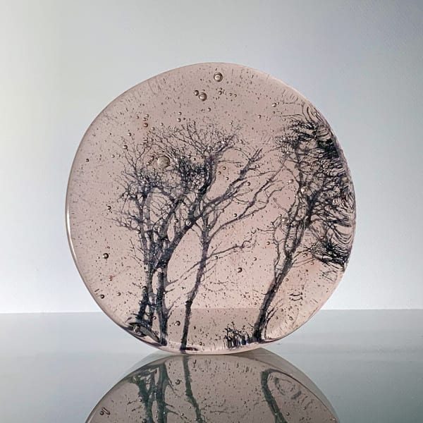 Helen Slater circular standalone glass sculpture of bare tree branches, set in light plum glass