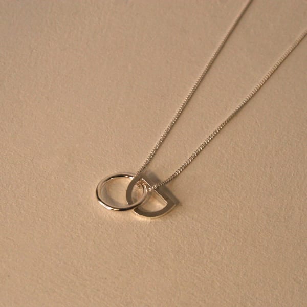Claire Lowe jewellery silver cahin necaklce with silver circle and arc shaped pendant linking one another