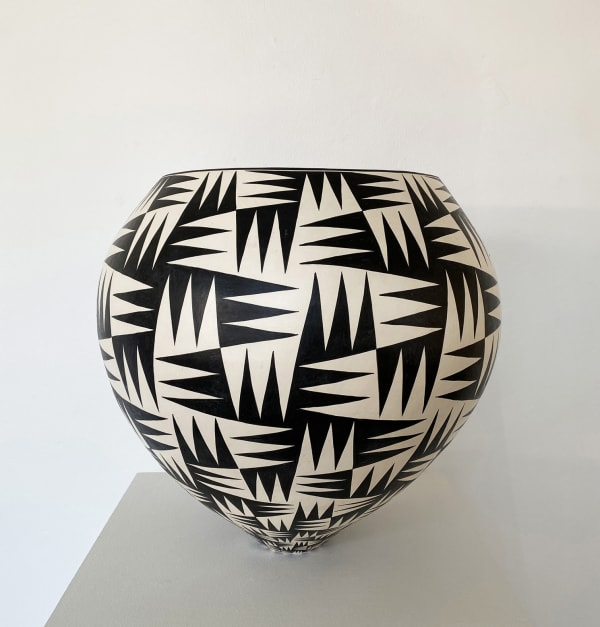Ant & Di Edmonds - Tydd Pottery wide, round ceramic black and white vessel with complex diagonal line patterns around it.