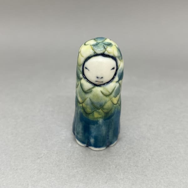 Marina Bauguil tiny sculpture of a plant spirit in blue and green with pointy scale shapes detail.