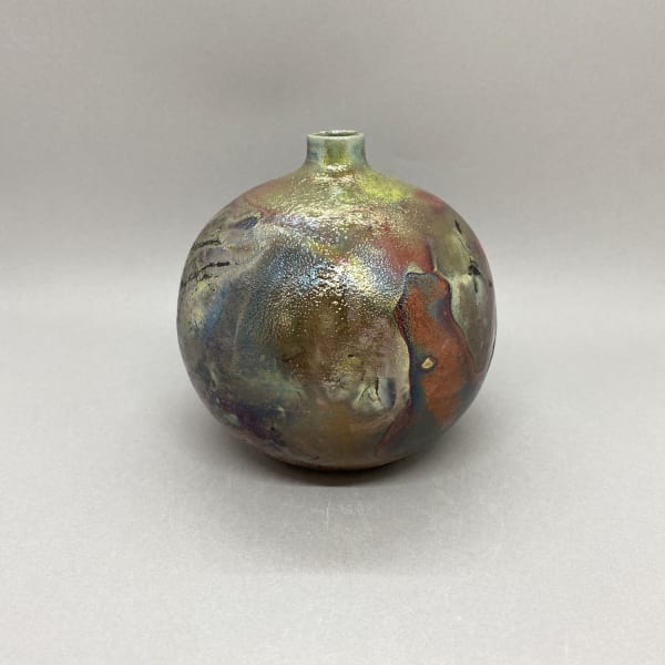 Katie Coston of Illyria Pottery raku fired round bottle vase with a short neck.