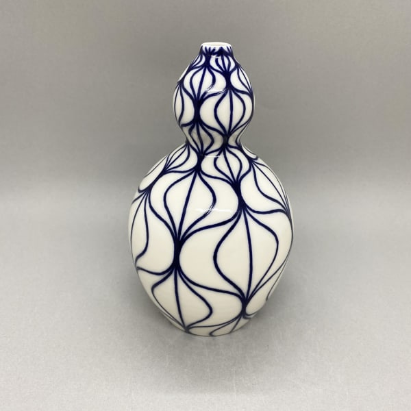 Rhian Malin medium white curvy shaped vase with wavy design in blue.