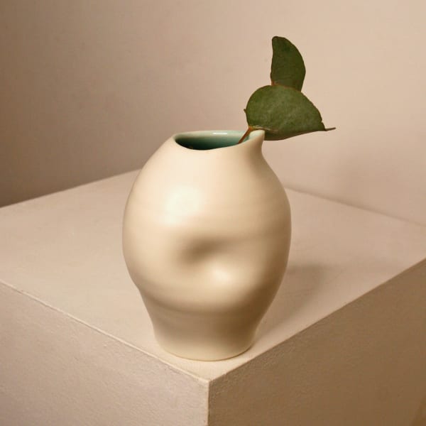 Linda Bloomfield ceramic pouring cup in an oval shape with a dimple in the centre, in white and blue