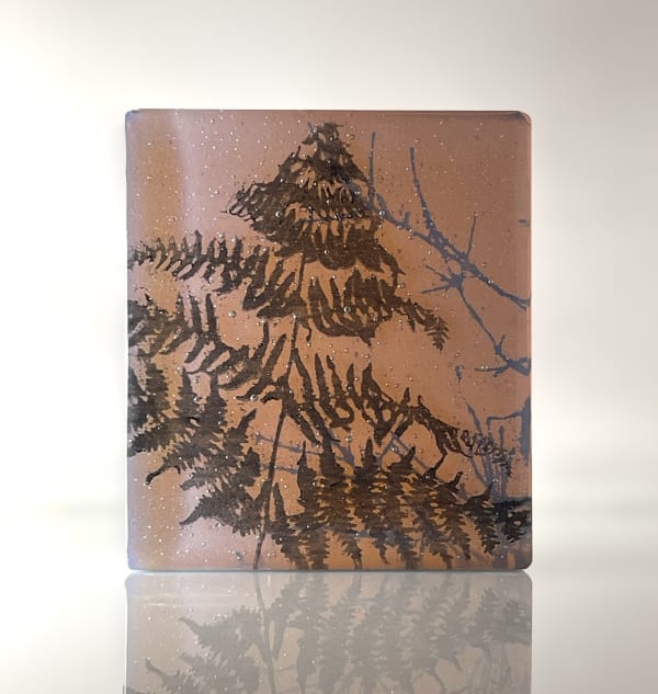 Helen Slater glass sculpture in dark amber and opaline glass with black drawings of grasses