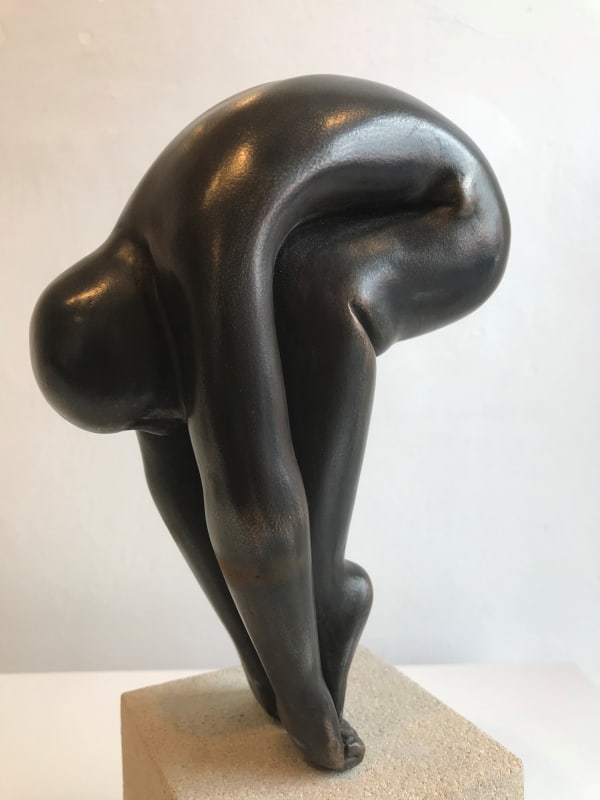 Peter Barker sculpture of a figure in black bending down to touch their toes.