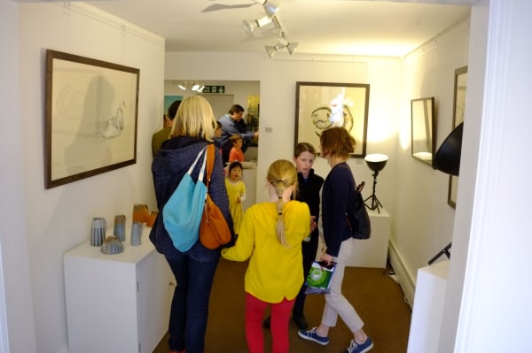 Some children and their families are looking at the art on display at Sarah Wiseman Gallery