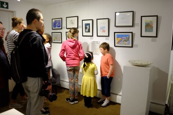 Some children and their families are looking at the art on display at Sarah Wiseman Gallery