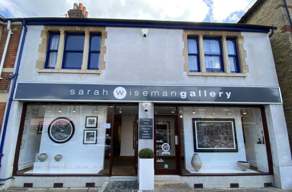 A view of Sarah Wiseman Gallery from outside. It's sunny weather and the windows display new works by Ade Adesina