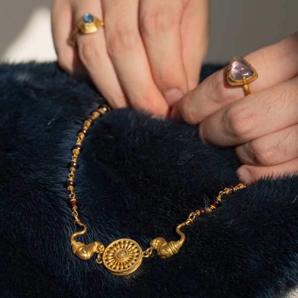 An Archaeological-Style Gold and Garnet Necklace in hands