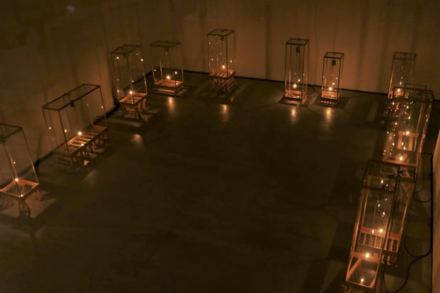 TSUYOSHI HISAKADO Gale, 2017 Wood, glass, aluminum, brass, LED lamp Dimensions variable USD 40,000.- 久門の作品にたびたび現れる時空間のコンセプトは、作品「風」（2017）で特に顕著である。ガラス箱の中で電球が振り子のように揺れ、見る者に時間の経過を形として感じさせる。この久門のインスタレーションはまるで劇場のように人々の感覚を開き、また多層の言及や暗示を含む。風と稲妻、そして雷という要素の組み合わせは、触ることができない巨大な力の存在を示唆するとともに、個人の存在の脆弱性の比喩でもある。