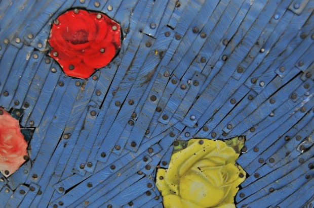 Detail of a bust of a woman rendered in colored strips of tin