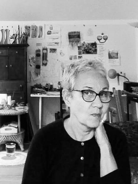 Black and white photograph of the artist Christine Hughes in her studio.