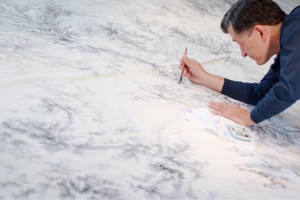 Profile photo of Arnold Chang working on his landscape painting