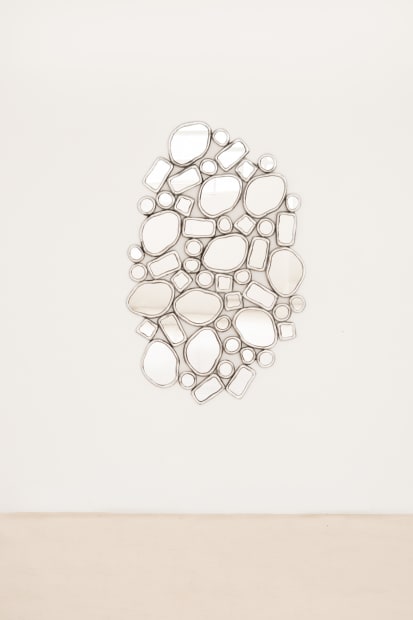 MIRROR, 2023 This mirror pairs a fused-glass surface with a bronze base composed from the modular rings that define the...