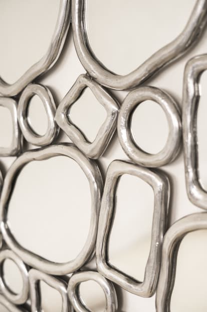 MIRROR, 2023 This mirror pairs a fused-glass surface with a bronze base composed from the modular rings that define the...