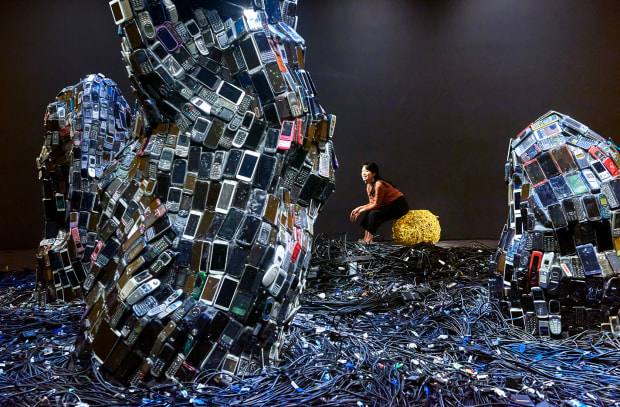 Miles of old computer cables on the floor encircle the scholar's rocks, suggesting ocean waves or the raked gravel of...