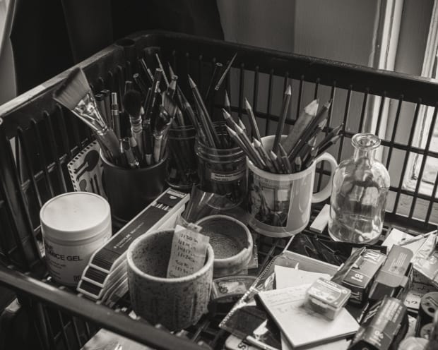 Black and White Photo of drawing utensils and cups in a basket in Zach oldenkamp's studio?