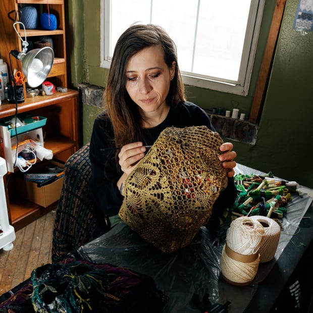 portrait of Caitlin McCormack working on crochet sculptural piece