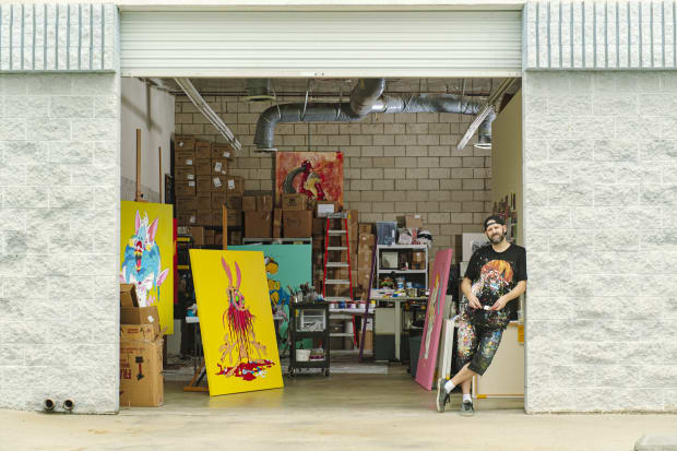 Photo of paintings and a person standing in a garage