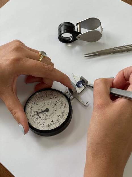 Sapphire gemstone being measured with professional gemmological tools for bespoke jewellery.