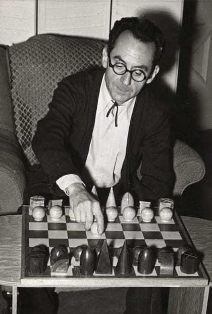 Man Ray (1890-1976) Man Ray with one of his designs for Chessmen, 1942 Gelatin silver print, printed c. 1960s Signed,...
