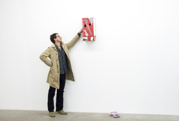 The Idiot is a wall-mounted bronze sculpture that replicates an empty Budweiser beer box, pierced with openings to resemble a...